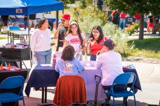 Students visiting a table at an Aims campus event