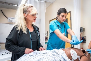 Instructor and student in the Acute Care Nurse Aide program at Aims