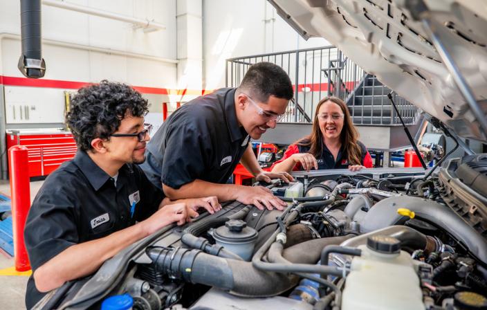 Aims automotive students work on a vehicle under the guidance of an instructor