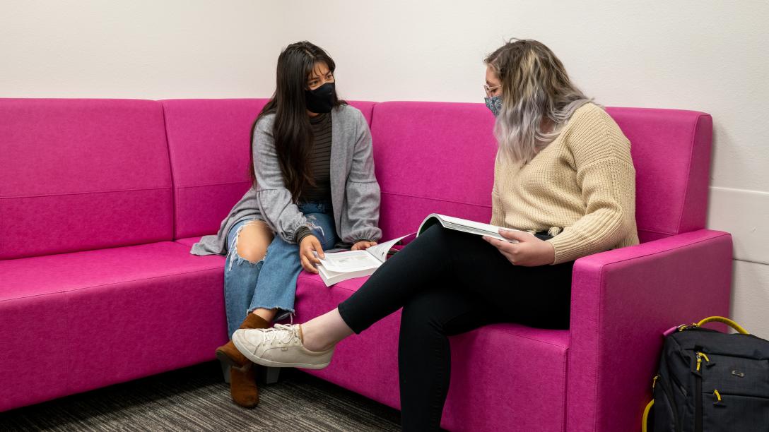 Aims students in the lounge wearing face masks, discussing books