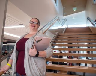 Student standing on stairs in Student Commons