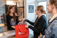 Two Students receiving items from Arty's Pantry staff
