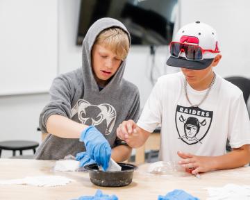 two boys working on pottery project