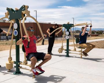 People using exercise equipment along the outdoor Fort Lupton Fitness Trail