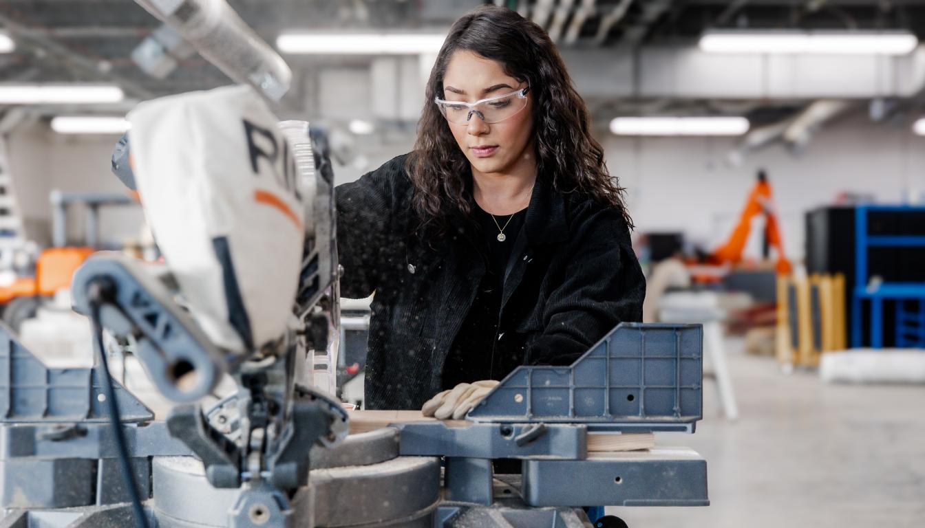 Female student using a power saw